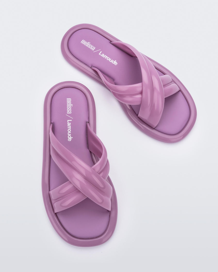 Top view of a pair of lilac Melissa Cali slides with cross straps.