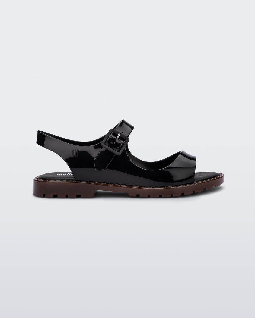 Side view of black Melissa Bae sandals with brown sole.