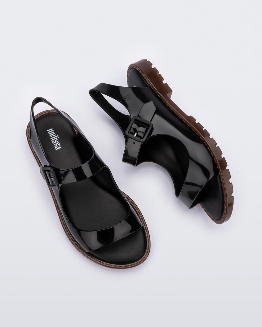 Top and side view of a pair of black Melissa Bae sandals with brown soles.