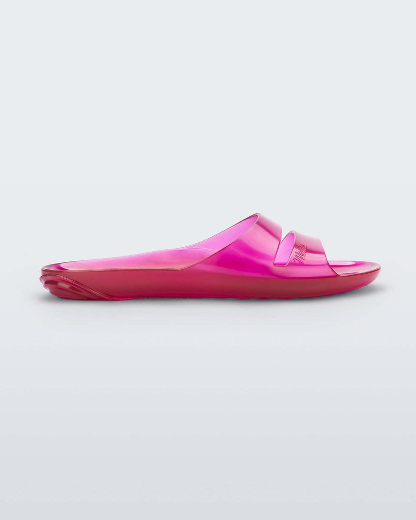 Side view of a clear pink Melissa Real Jelly Slide with two front straps.