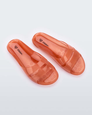 Top view of a pair of clear orange Melissa Real Jelly Slides with two front straps.