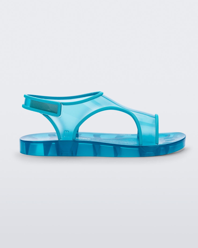 Side view of a translucent blue Mini Melissa Aqua sandal with two straps cojoining in the middle and a velcro back strap.