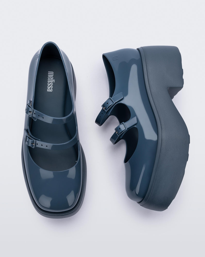 A top and side view of a pair of blue Melissa Farah platform shoes with two straps fastened by blue buckles.