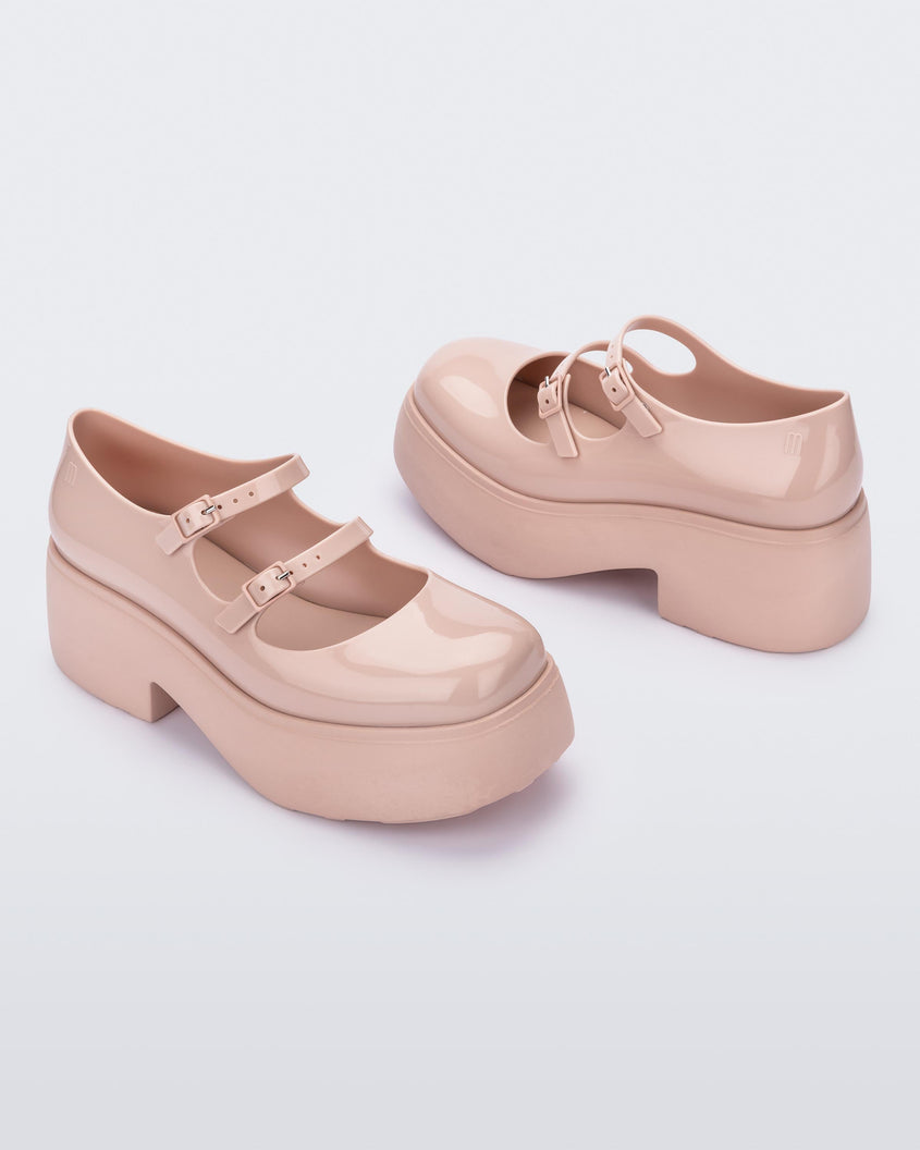 A top and side view of a pair of pink Melissa Farah platform shoes with two straps fastened by pink buckles.