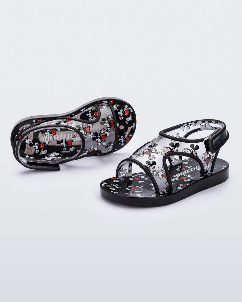 Angled view of a pair of black Mini Melissa Acqua sandals with Mickey Mouse print