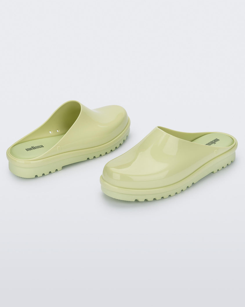 An angled side and back view of a pair of green Melissa Smart Clogs.