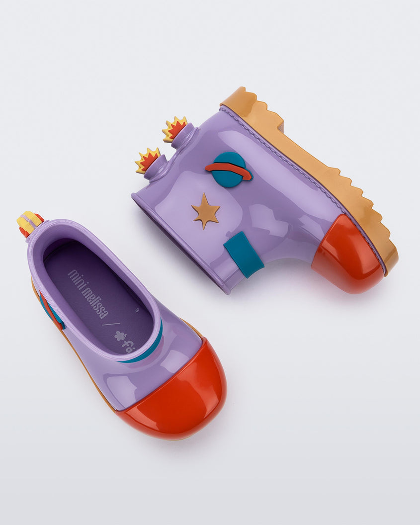 A top and side view of a pair of carmel/lilac/red Mini Melissa Rain Boots with a lilac base, red toe, brown sole, and a planet, star and fire detail on the side and back.