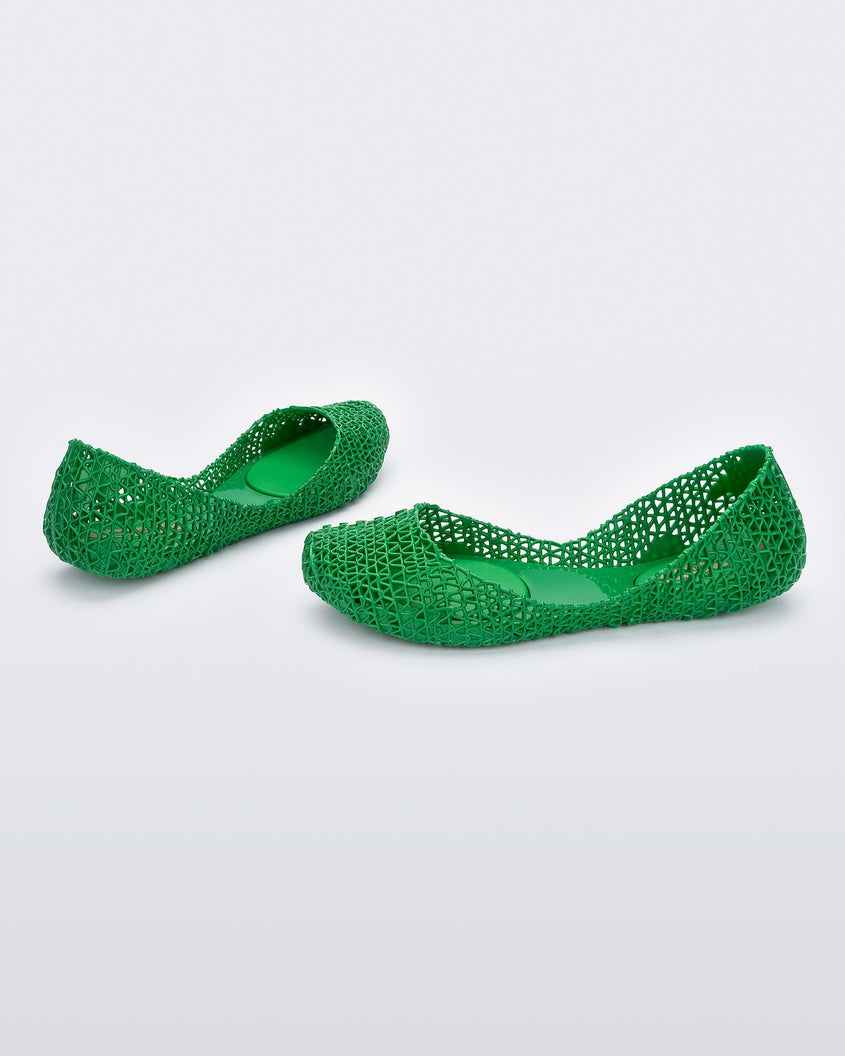 Angled view of a pair of Melissa Campana flats in green with an open woven texture. 
