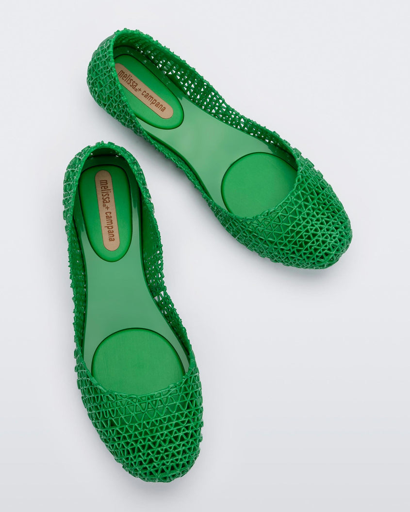 Top view of a pair of Melissa Campana flats in green with an open woven texture.