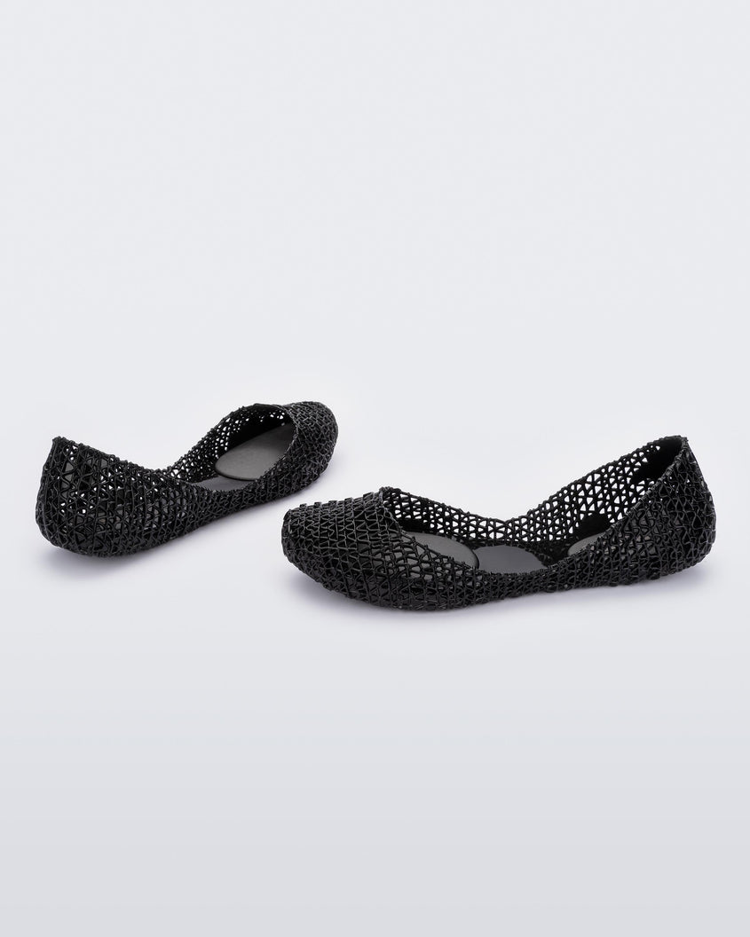 Angled view of a pair of Melissa Campana flats in black with an open woven texture. 