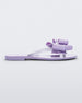 Side view of a lilac Melissa Harmonic Sweet flip flop with a lilac bow and clear glitter straps.