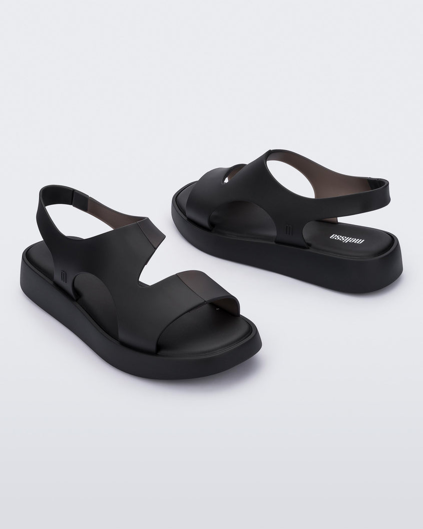 An inner and outter side view of a pair of black Melissa Franny sandals with straps.