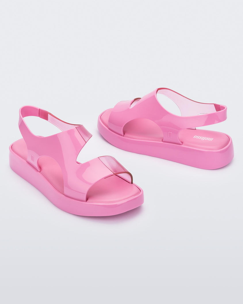 A top and side view of a pair of pink Melissa Franny sandals with straps.