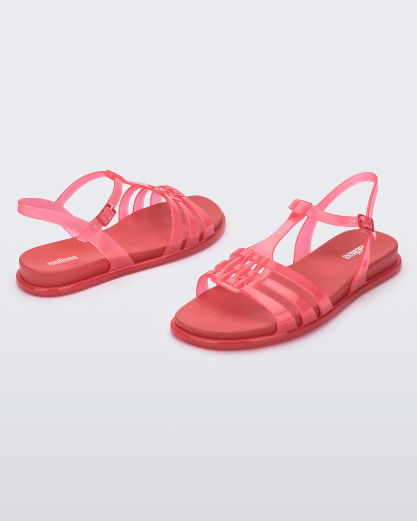 An angled side and back view of a pair of red Melissa Party sandals with back ankle strap and buckle closure.