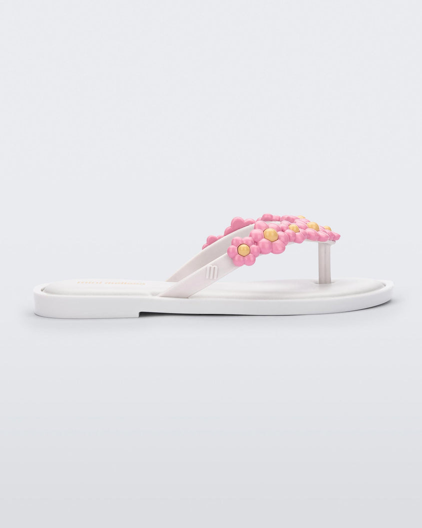 Side view of a white Mini Melissa Spring Flip Flop with pink and yellow flowers.