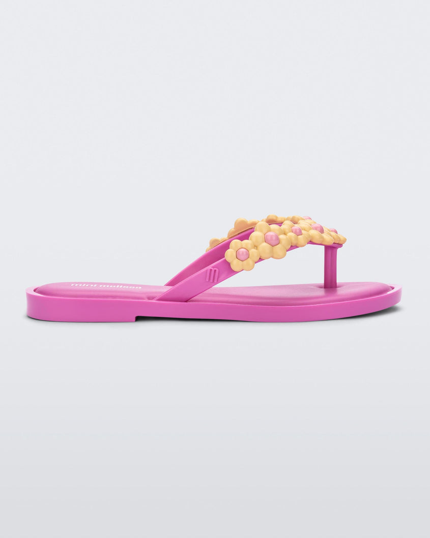 Side view of a pink Mini Melissa Spring Flip Flop with yellow and pink flowers.