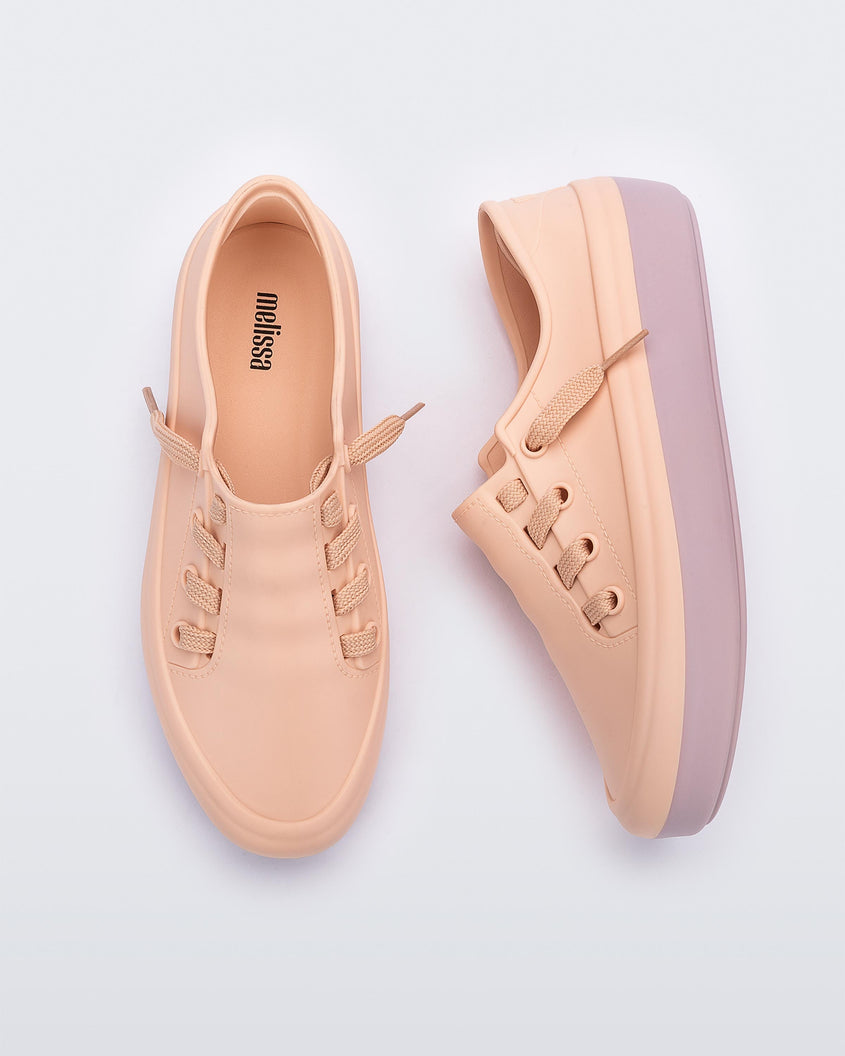 A top and side view of a pair of pink Melissa Ulitsa sneakers with a pink base and laces.