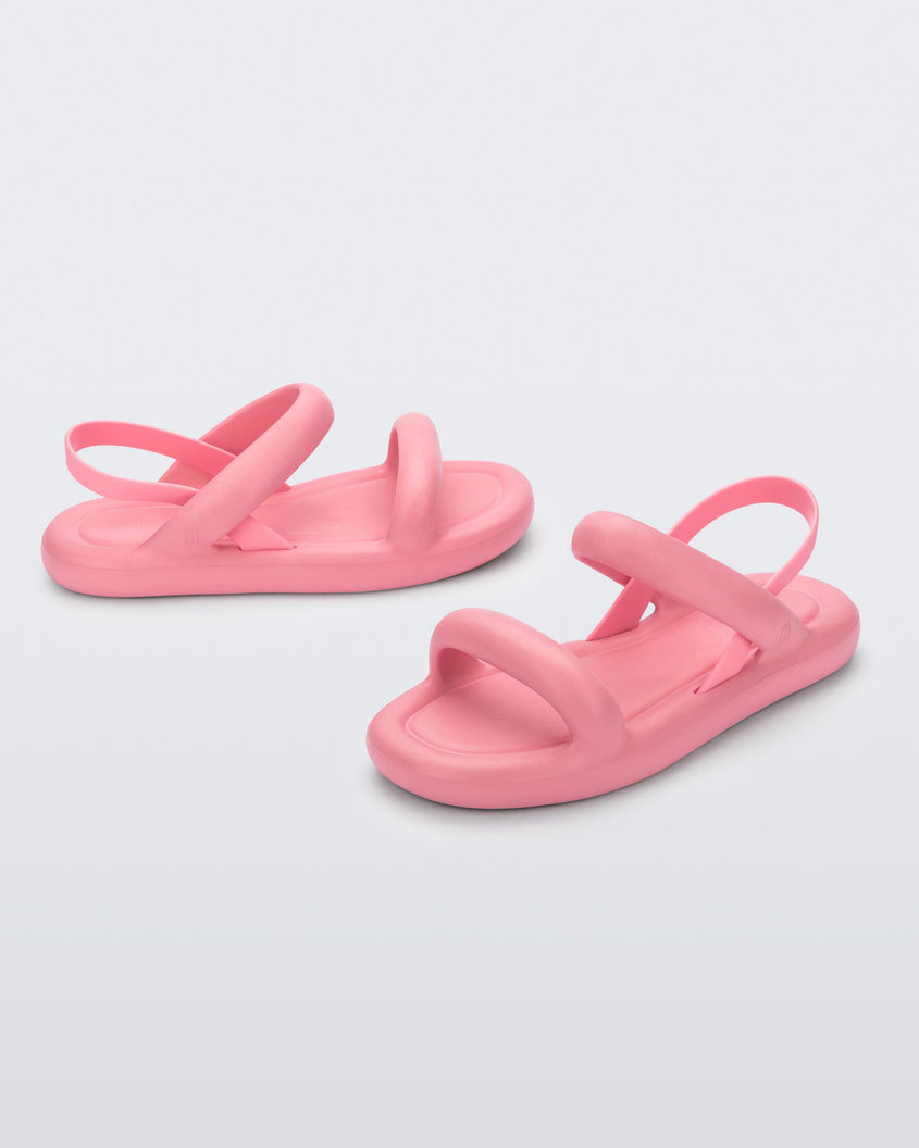 A side and angled view of a pair of pink Melissa Free Bloom Sandals with puffer-like straps.