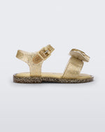 Side view of a yellow glitter Mini Melissa Mar Sandal with a heart shaped bow and buckle.