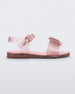 Side view of a glitter pink Mini Melissa Mar Sandal with a bow.