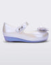 Side view of a pearly blue Mini Melissa Ultragirl flat with a top strap and a heart bow buckle on the toe.
