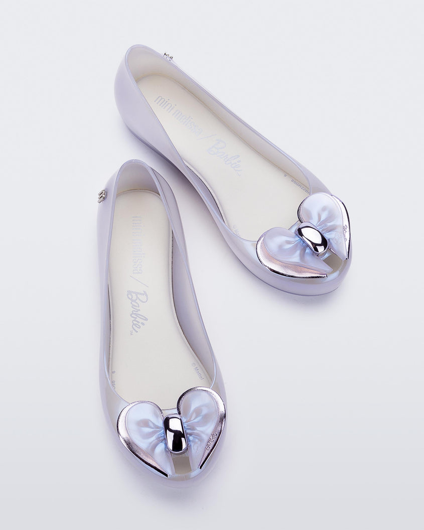 A top view of a pair of pearly blue Mini Melissa Ultragirl flats with a pearly blue base and a heart buckle bow detail on the toe.