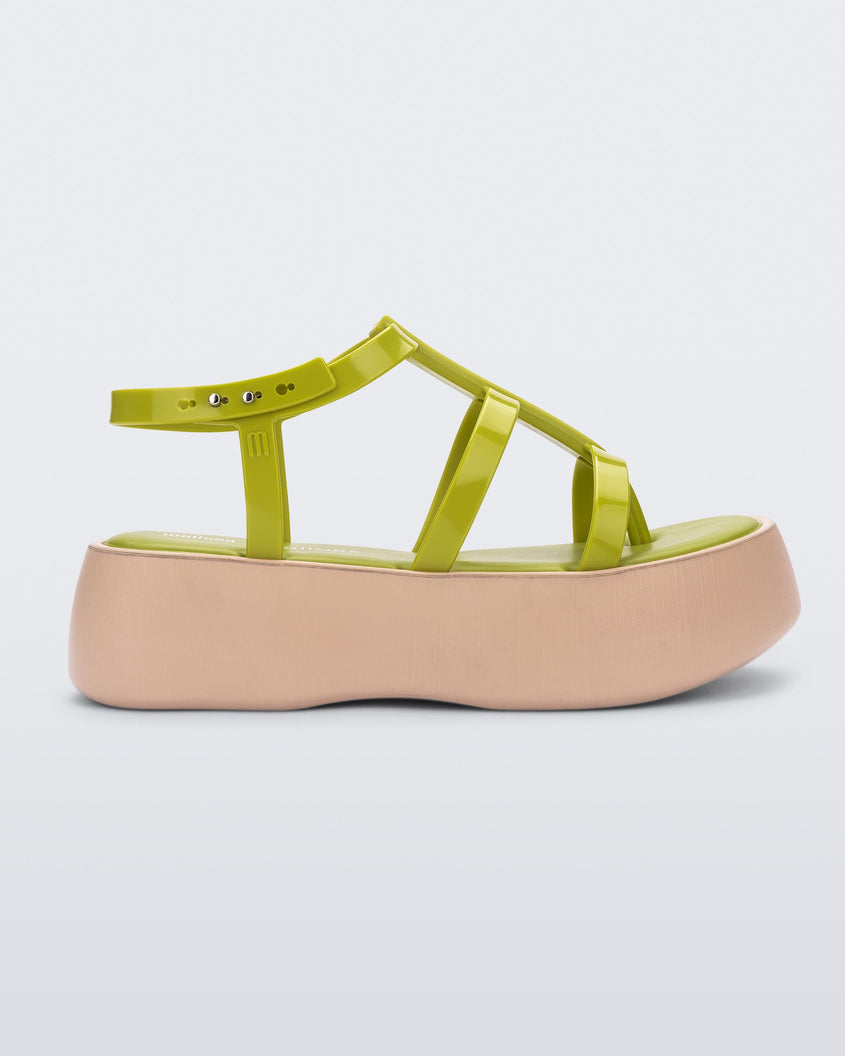 Side view of a beige/green Melissa Caribe High Platform sandal with two green front straps joined by a vertical strap intersecting the ankle strap and a beige sole.