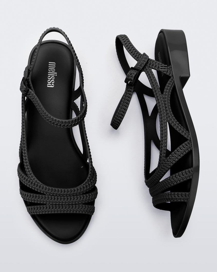 A top and side view of a pair of black Melissa Femme Classy sandals with straps and a woven design.