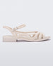 Side view of a beige Melissa Femme Classy sandal with straps and a woven design.