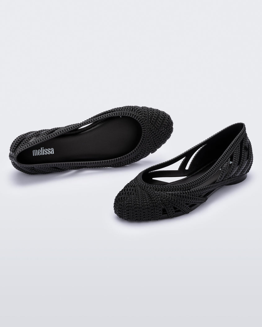 A top and side view of a pair of black Melissa Femme Classy flats with a woven design.