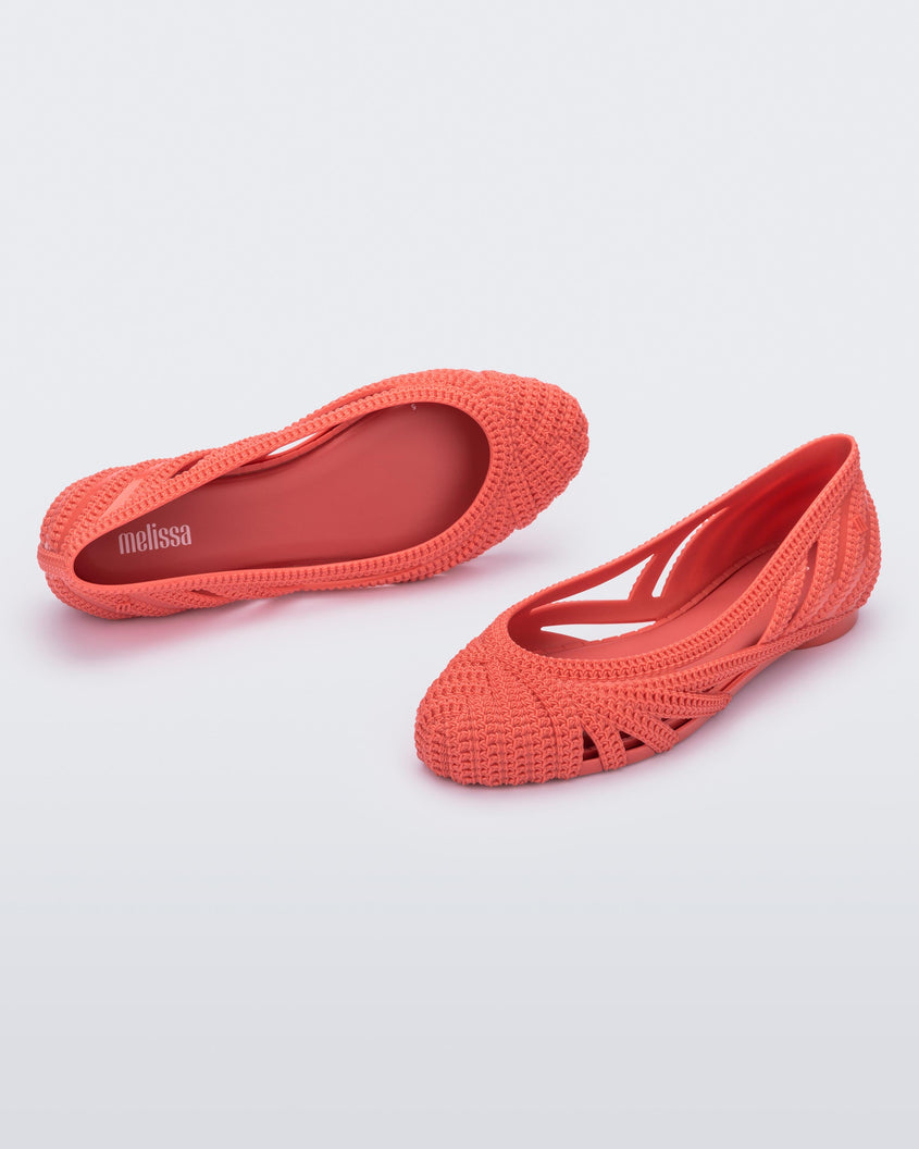 A top and side view of a pair of red Melissa Femme Classy flats with a woven design.
