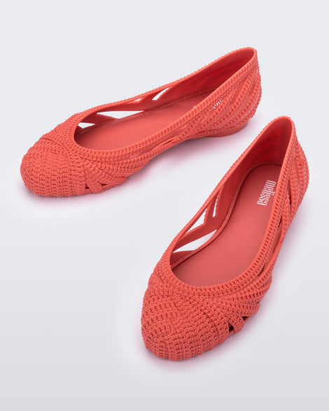A top view of a pair of red Melissa Femme Classy flats with a woven design.