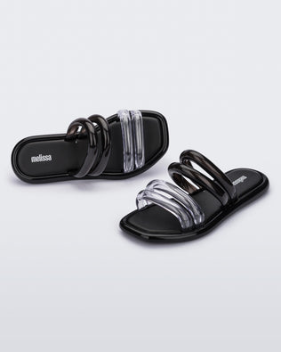 Top and angled view of a pair of black and clear Melissa Airbubble Slides