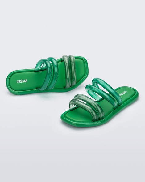Top and angled view of a pair of  green and transparent green Melissa Airbubble slides.