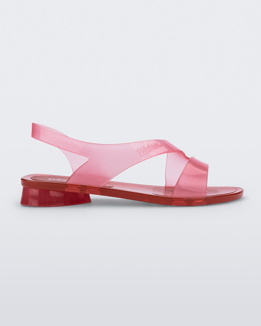 Side view of a pink/red Melissa The Real Jelly Paris sandal with two front straps and an ankle strap.