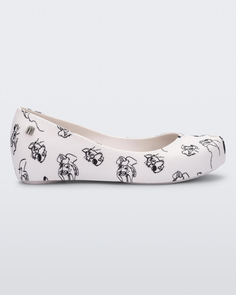 Side view of a white/grey Mini Melissa Ultragirl Cats & Dogs flat with a white base and cartoon dog face drawing pattern across the base.
