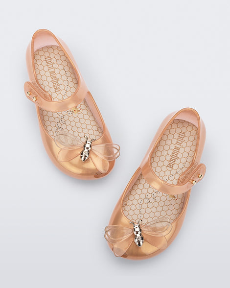 Top view of a pair of pearly orange Mini Melissa Ultragirl Bugs flats with a top strap and bug detail buckle on the toe.