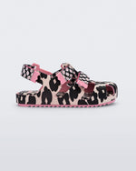 Side view of a pink/black Mini Melissa Yoyo sandal with a pink and black floral base, two velcro front straps and a back ankle strap.