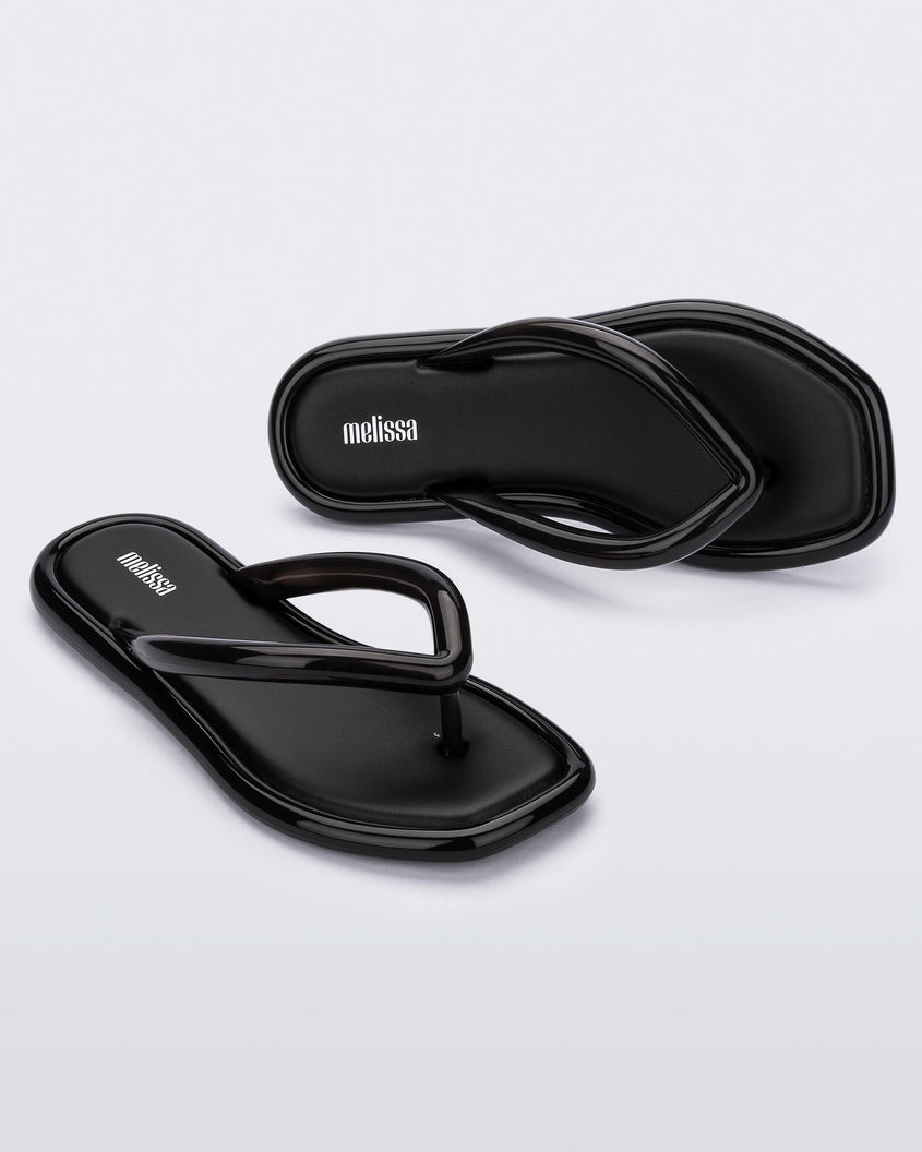 Angled view of a pair of black Melissa Airbubble Flip Flops.
