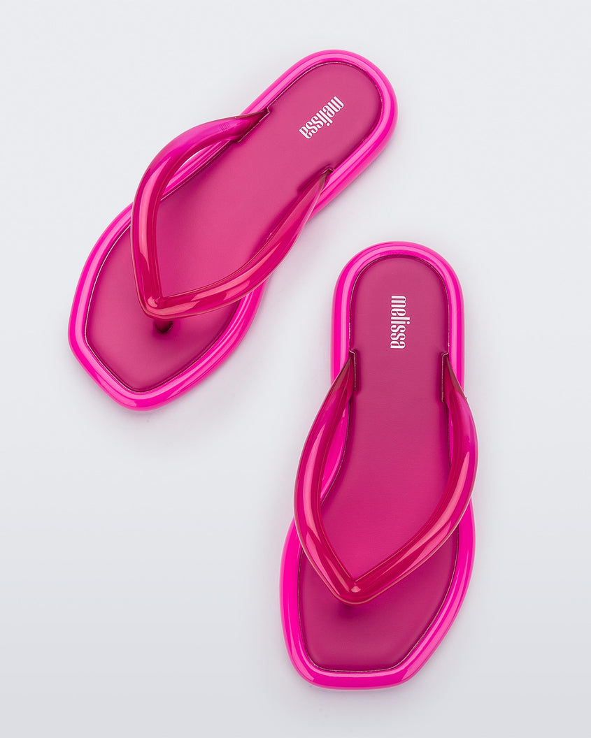 Top view of a pair of dark pink Melissa Airbubble Flip Flops.