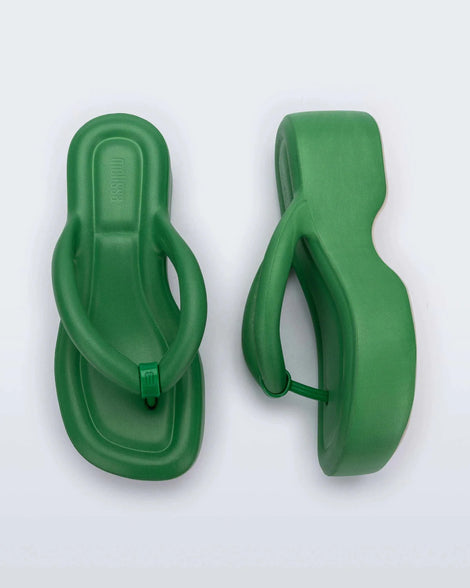 A top and side view of a pair of green Melissa Free Platform flip flops with puffer-like straps.