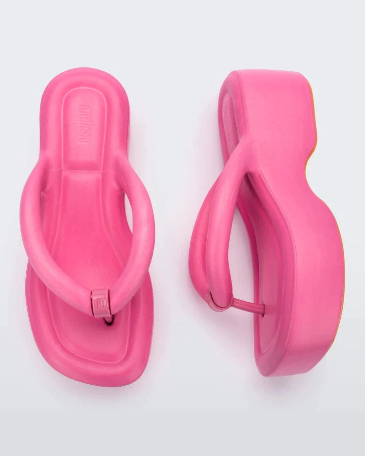 Top and side view of a pair of pink Melissa Free Platform Flip Flops with puffer-like straps.