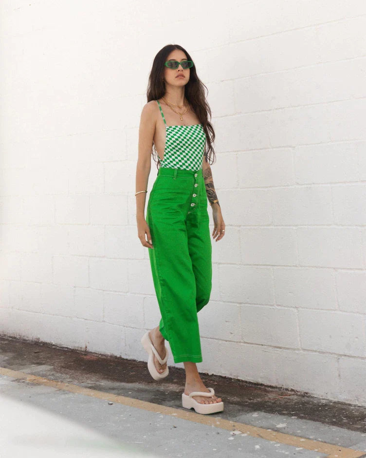 A model posing for a picture wearing a green jumpsuit and a pair of beige Melissa Free Platform Flip Flops with puffer-like straps.