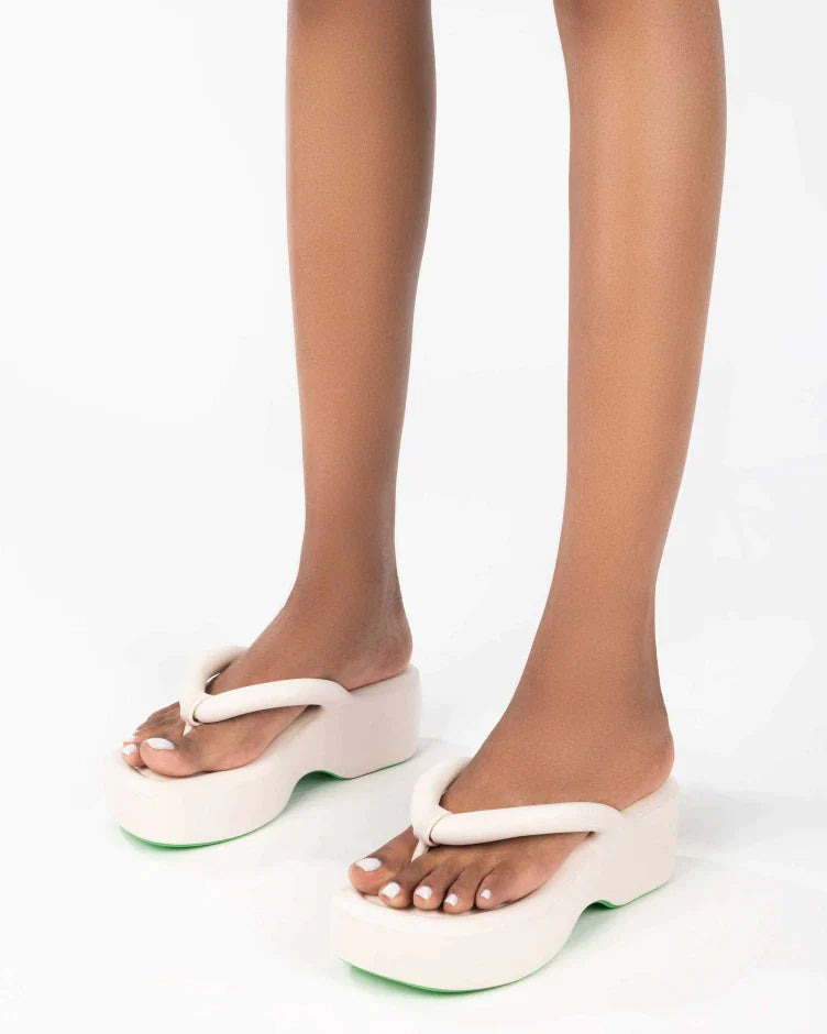 A model's legs wearing a pair of beige Melissa Free Platform Flip Flops with puffer-like straps.