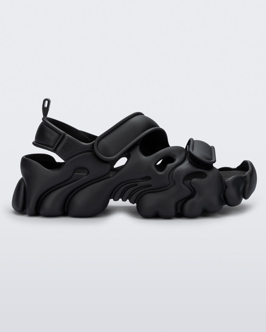 Side view of a Melissa Puff chunky sandal in black with velcro straps