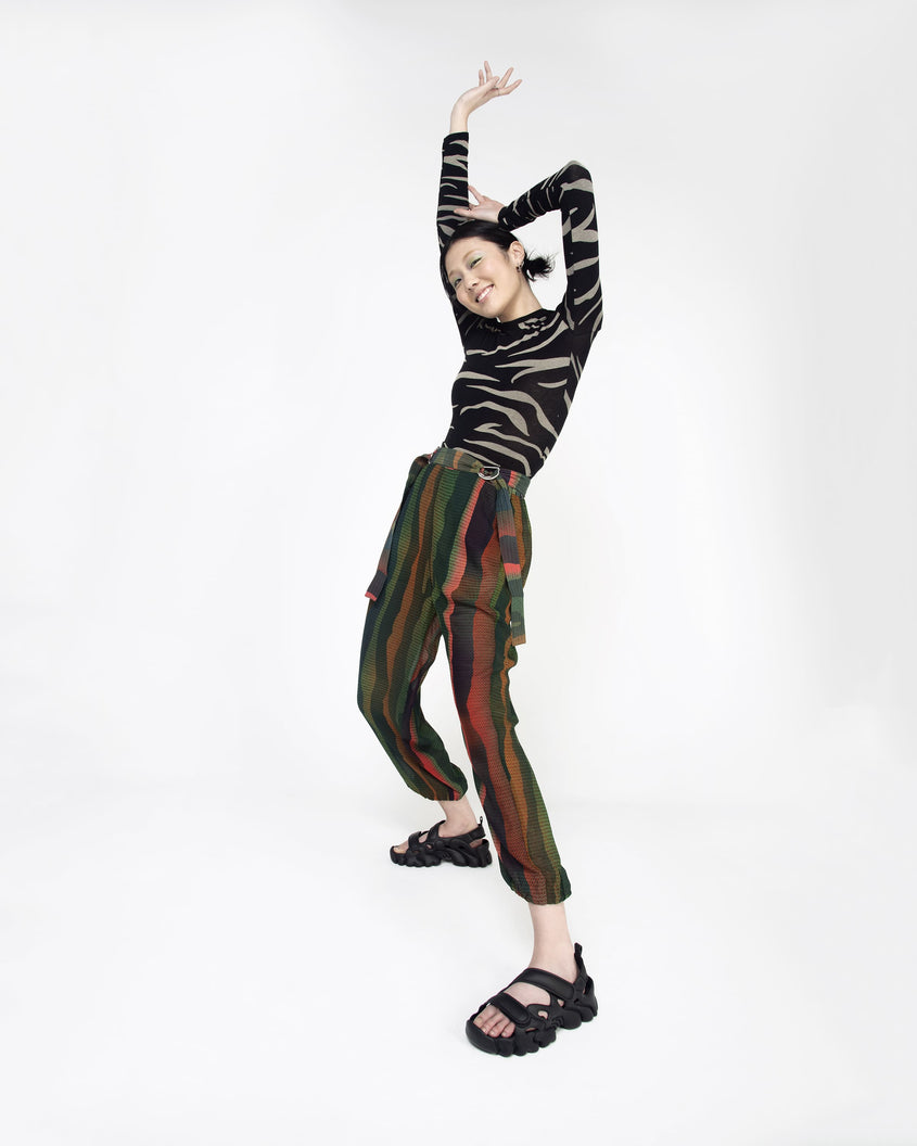 Model posing in patterned pants wearing a pair of Melissa Puff chunky sandals in black with velcro straps