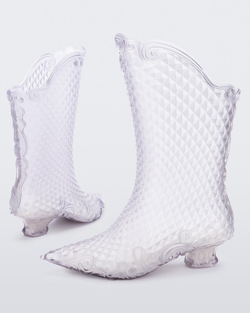 A back and side view of a pair of transparent glass looking Melissa Court Boots with a short heel, heart detail on the front and a checkered pattern texture.