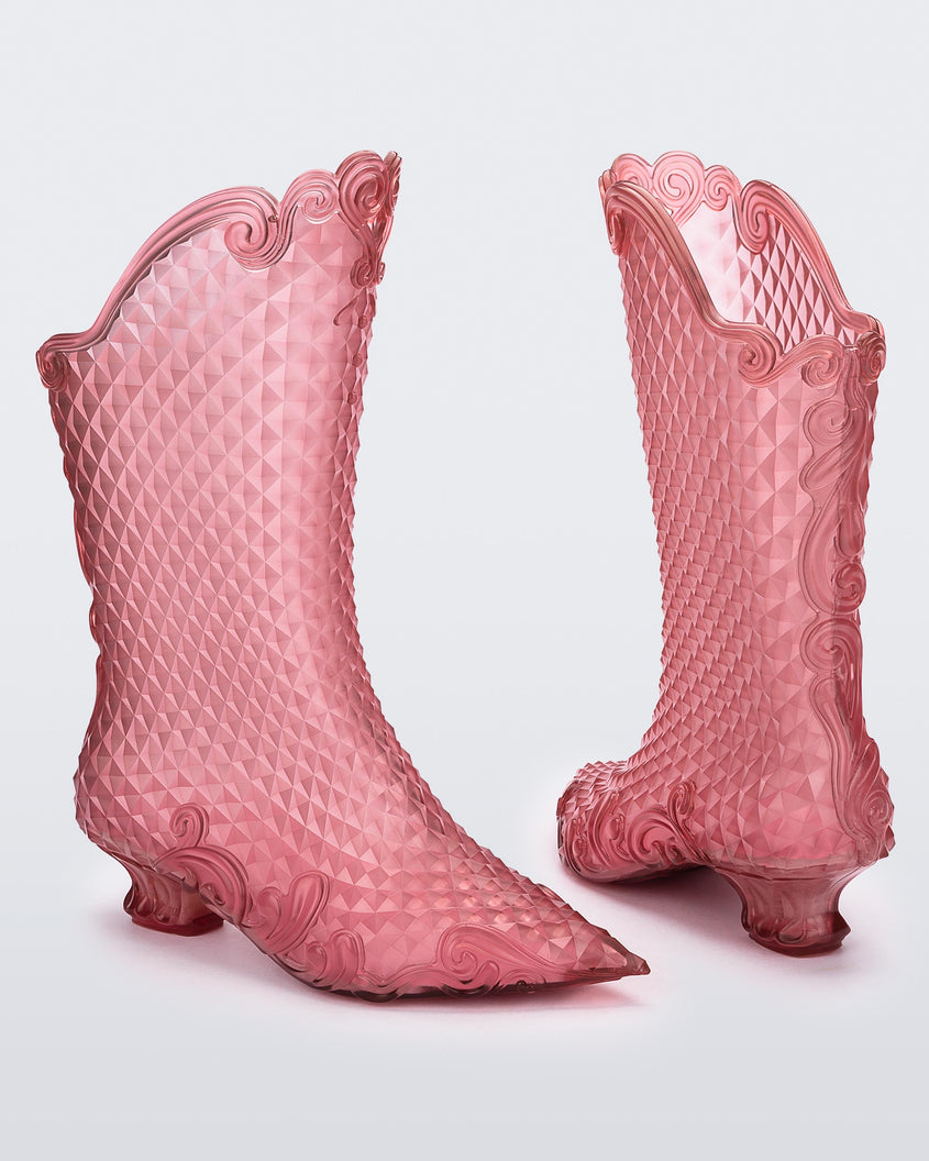 An angled front and back view of a pair of clear pink Melissa Court Boots with a short heel, heart detail on the front and a checkered pattern texture.