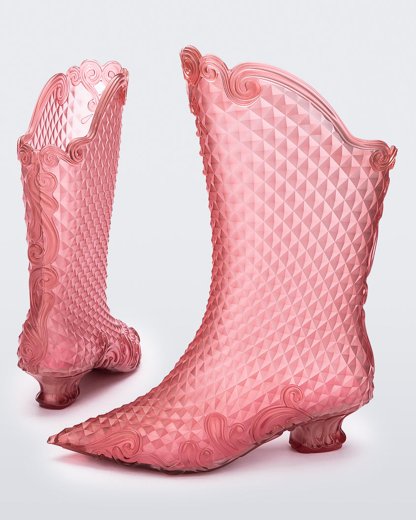A back and side view of a pair of clear pink Melissa Court Boots with a short heel, heart detail on the front and a checkered pattern texture.