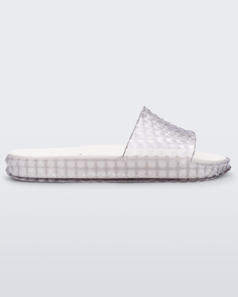 Side view of a clear/white Melissa Court Slide with a checkered pattern texture.